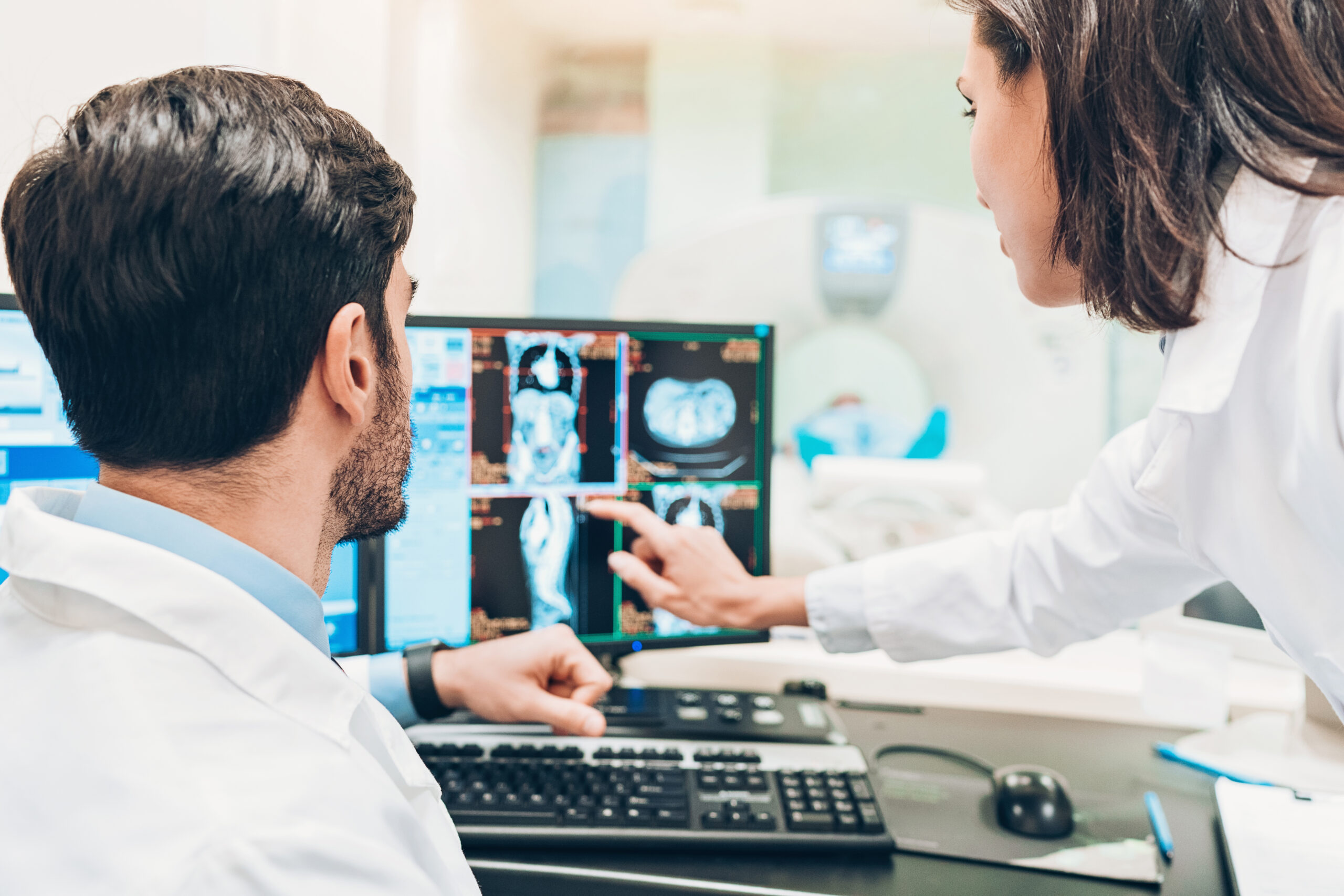 Two doctors looking over an MRI scan on a computer